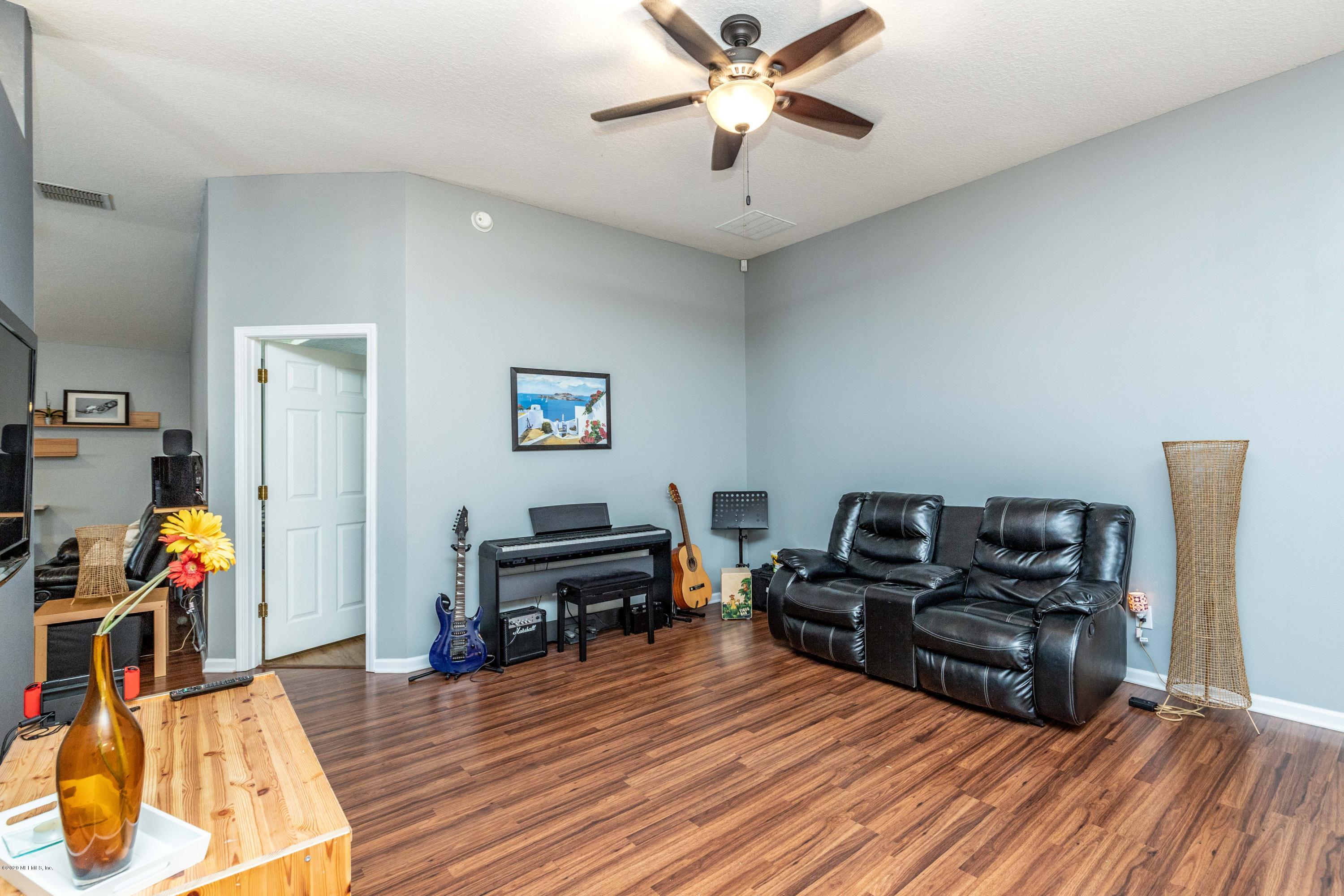 816 Crystal Spring Way St. Augustine, FL 32092 - Photo 10 of 44 a living room with furniture a flat screen tv and a bookshelf