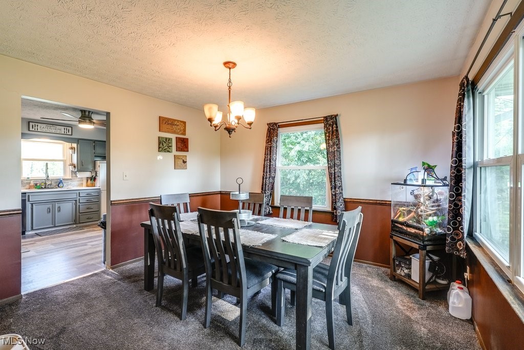 3066 Prior Road Akron, OH 44319 - Photo 7 of 50 Dining area with a textured ceiling, a healthy amount of sunlight, and ceiling fan with notable chandelier