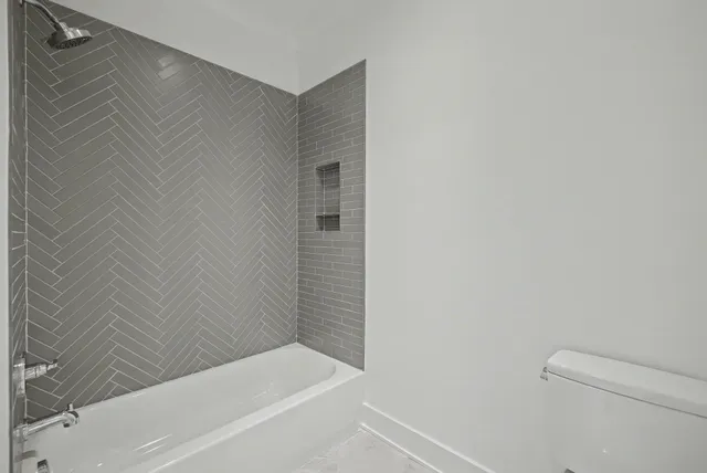 a view of a livingroom with a ceiling fan & windows