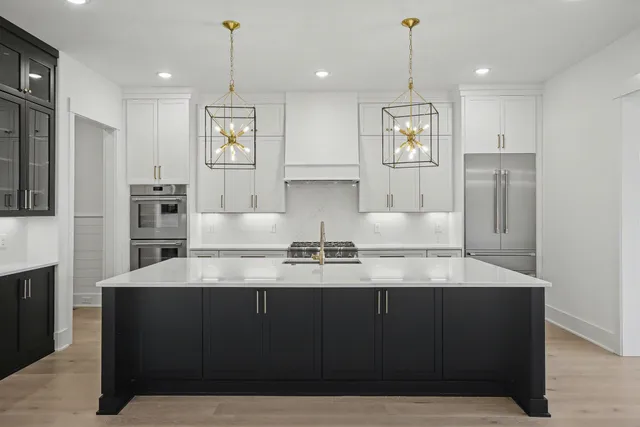 a kitchen with granite countertop white cabinets and stainless steel appliances