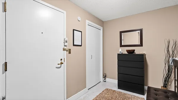 a view of a hallway with closet and dresser