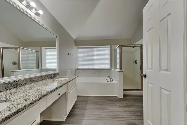 a spacious bathroom with a granite countertop tub sink and mirror