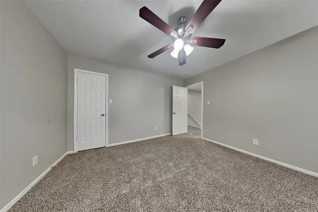 a view of an empty room with a chandelier fan