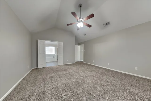 a view of an empty room with a chandelier fan