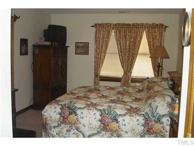 6240 Lookout Loop Raleigh, NC 27612 - Photo 13 of 19 a bedroom with a bed and tv