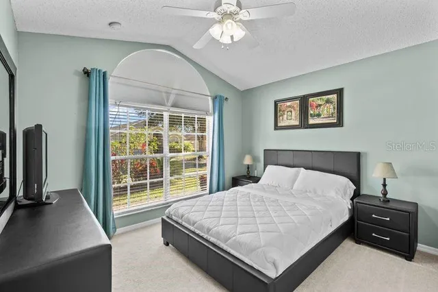 a bedroom with a bed and a flat tv screen on the dresser