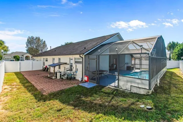 a view of a house with backyard and sitting area