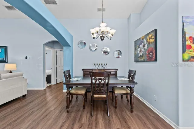 a view of a dining room with furniture wooden floor and a chandelier