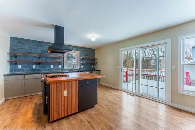 a kitchen with stainless steel appliances granite countertop a stove a sink and a large window