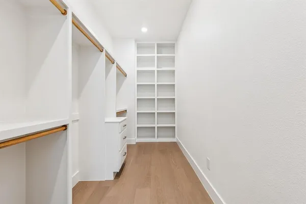 a view of walk in closet with empty racks