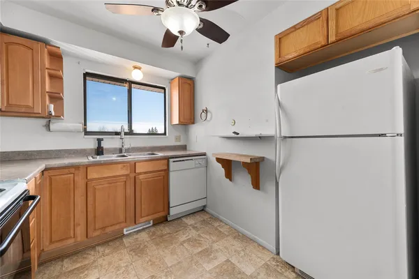 a kitchen with stainless steel appliances white cabinets and a refrigerator