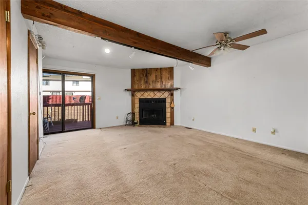 a view of an empty room with a fireplace and a window