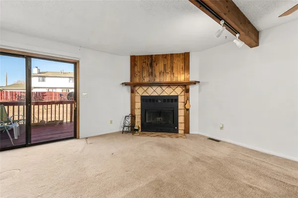 a view of an empty room with a fireplace and a window