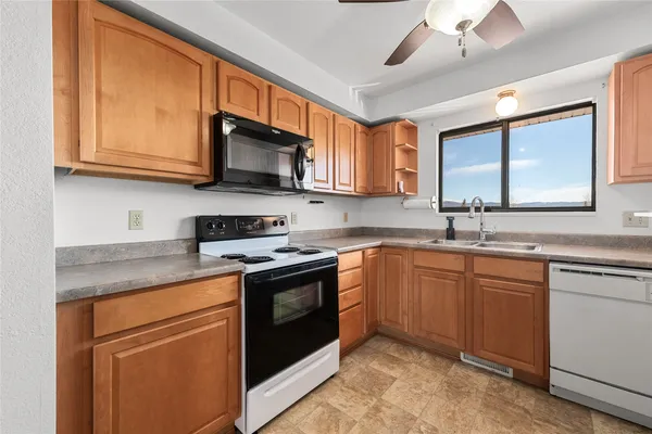 a kitchen with stainless steel appliances granite countertop a sink stove and microwave