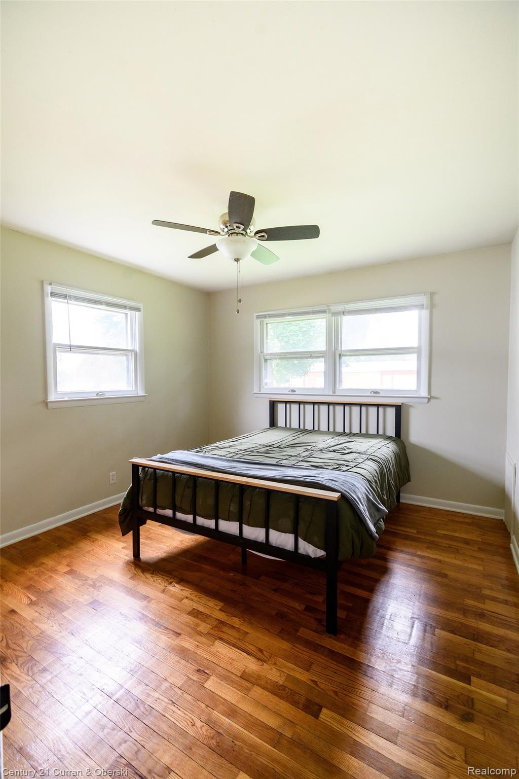 5260 Rives Junction Road Jackson, MI 49201 - Photo 20 of 44 Bright room featuring wood-finish flooring, a ceiling fan with integrated lighting, and multiple windows with blinds