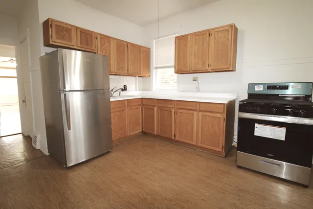 a kitchen with stainless steel appliances granite countertop a refrigerator stove and sink