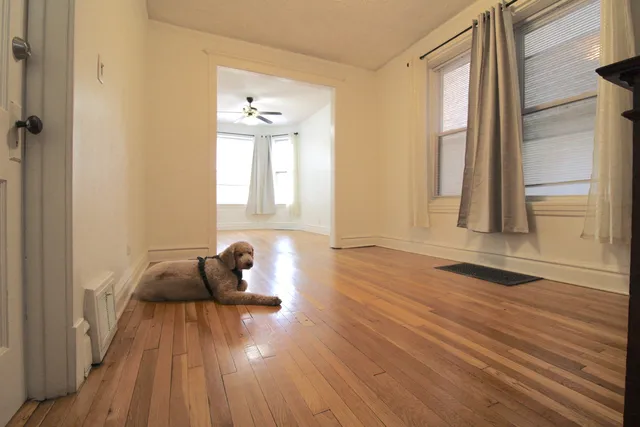 a hallway with wooden floor and a bathroom