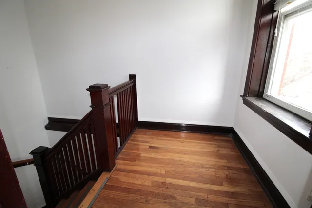 a view of a hallway with wooden floor and staircase