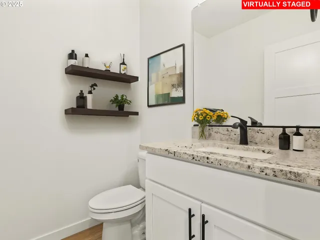 a bathroom with a granite countertop sink and a toilet