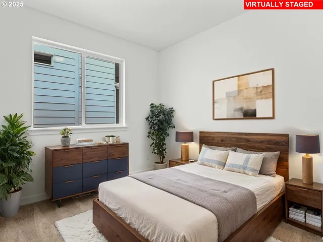 a bedroom with a large bed and a potted plant
