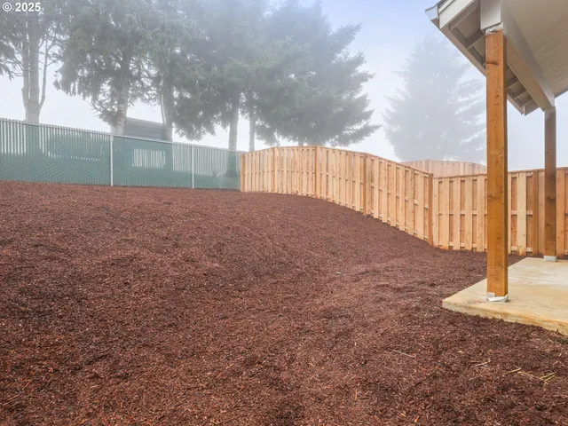 a view of backyard with wooden fence
