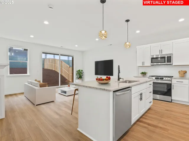 a view of kitchen with stainless steel appliances granite countertop a stove top oven a sink dishwasher a dining table and chairs with wooden floor