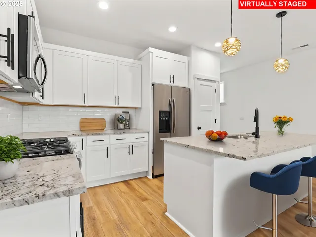 a kitchen with stainless steel appliances granite countertop a sink refrigerator and cabinets