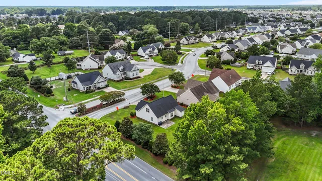 an aerial view of residential houses with outdoor space and trees