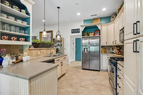 a kitchen with a stove a sink and a wooden floor