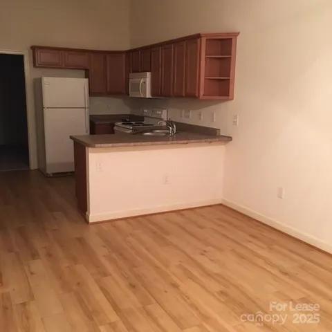 a view of a kitchen with a sink and a refrigerator
