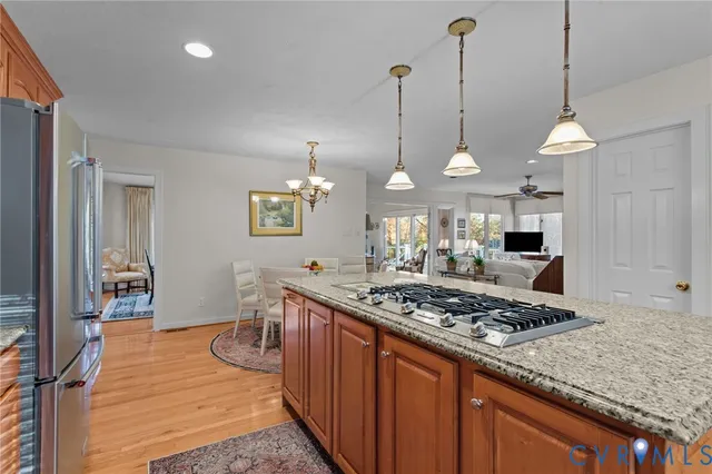 a kitchen with stainless steel appliances granite countertop a stove a sink and a wooden floors