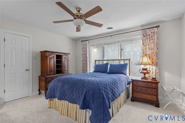 a bedroom with a bed next to a window and a chandelier