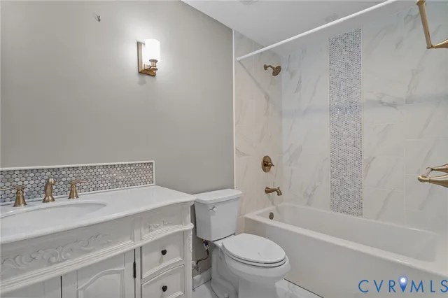 a bathroom with a granite countertop sink a toilet and shower
