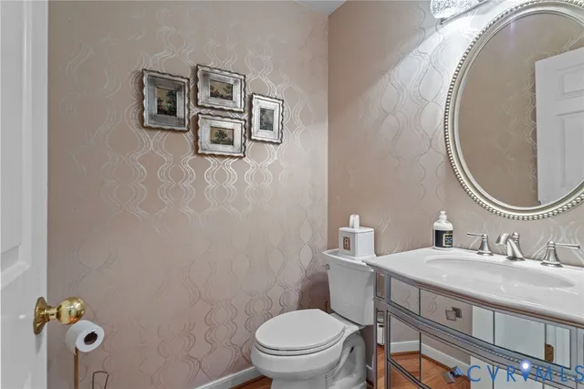 a bathroom with a granite countertop toilet a sink and mirror