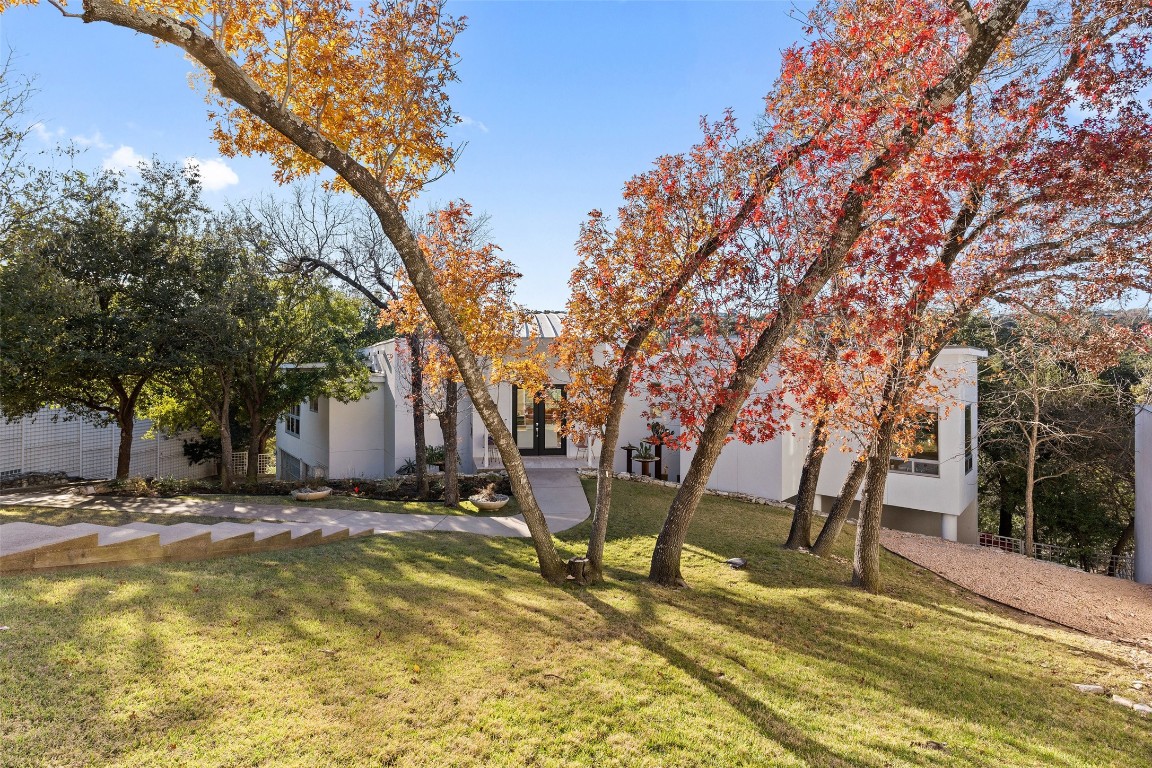 2102 North Oak Canyon Road Austin, TX 78746 - Photo 2 of 40 a view of patio with chairs and table under an umbrella