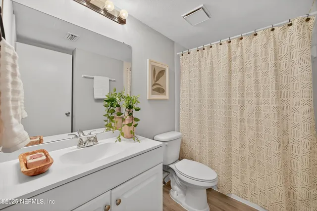 a bathroom with a sink a toilet and shower curtain