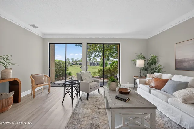a living room with furniture and large windows