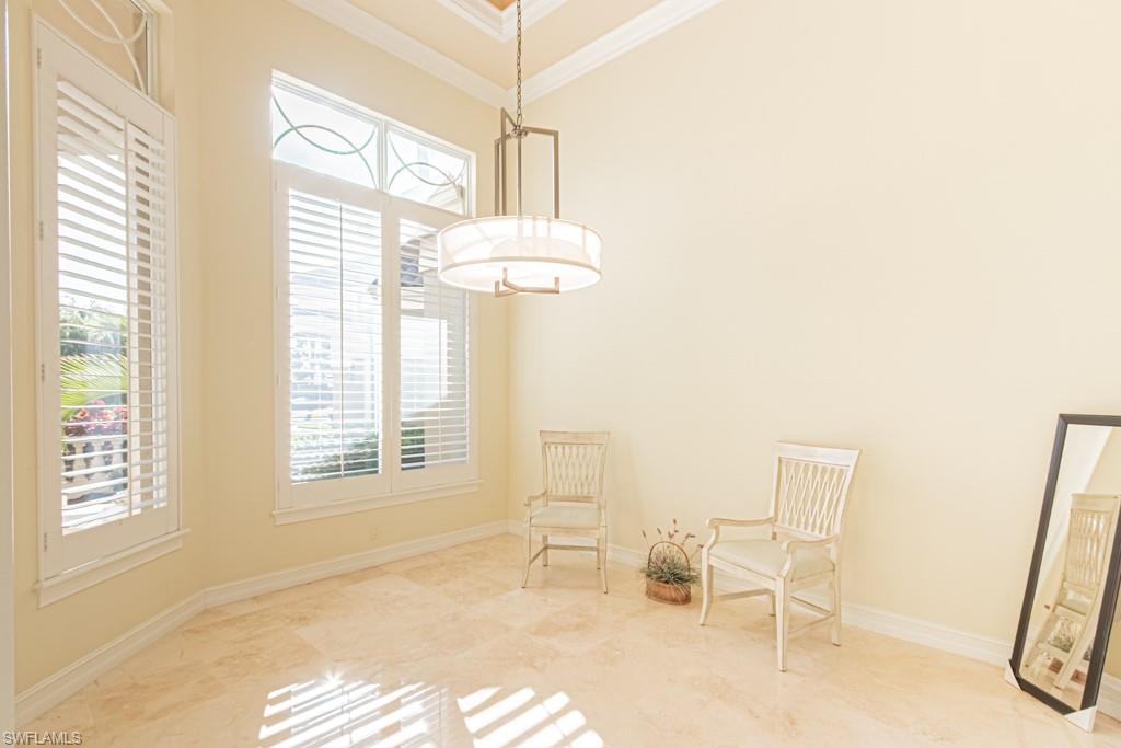 1676 Persimmon Drive Naples, FL 34109 - Photo 11 of 50 a bedroom with a bed and a chandelier