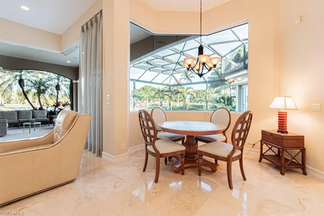 a dining room with furniture and a floor to ceiling window