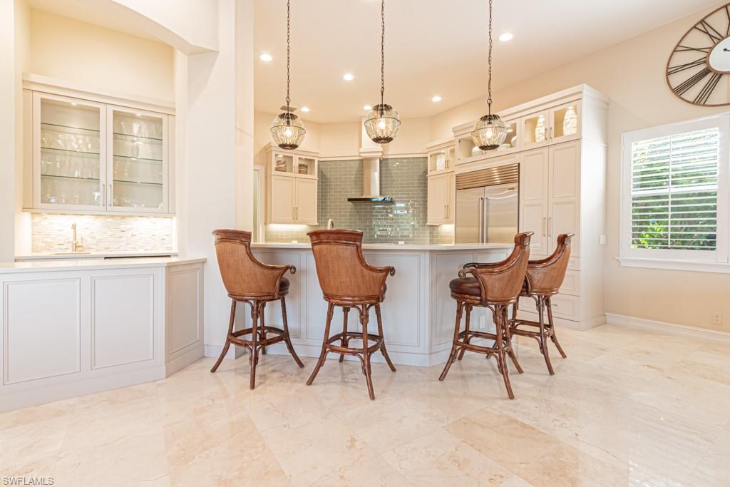 1676 Persimmon Drive Naples, FL 34109 - Photo 17 of 50 a view of a dining room with furniture and a chandelier