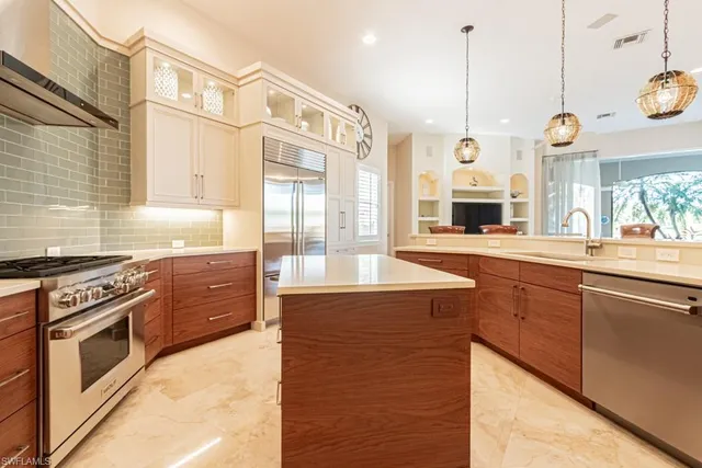 a kitchen with stainless steel appliances granite countertop a stove a sink and a wooden floors