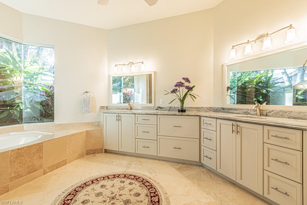 1676 Persimmon Drive Naples, FL 34109 - Photo 28 of 50 a spacious bathroom with sinks mirror and a bathtub