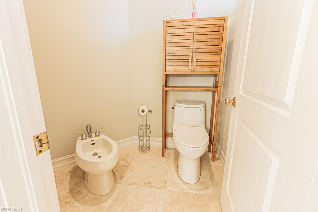 1676 Persimmon Drive Naples, FL 34109 - Photo 31 of 50 a bathroom with a granite countertop toilet and a sink