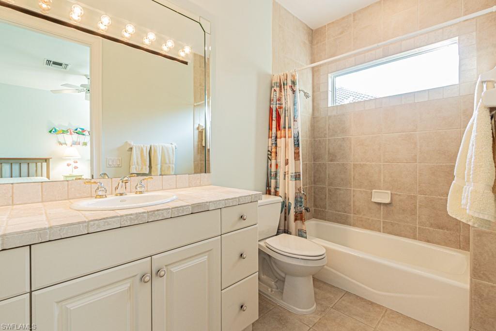 1676 Persimmon Drive Naples, FL 34109 - Photo 36 of 50 a bathroom with a toilet a sink and a bathtub