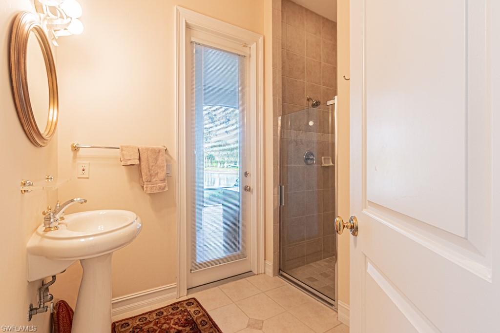 1676 Persimmon Drive Naples, FL 34109 - Photo 39 of 50 a bathroom with a sink a mirror and a shower