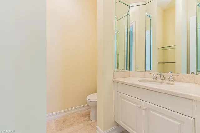 a bathroom with a granite countertop sink a toilet and a mirror