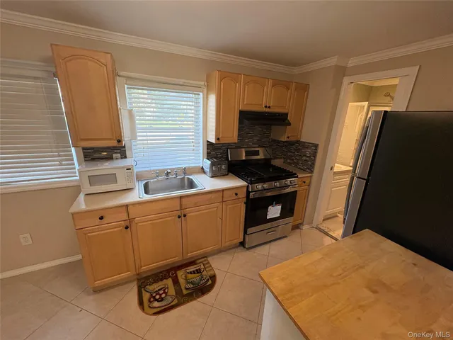 a kitchen with granite countertop a refrigerator stove and sink
