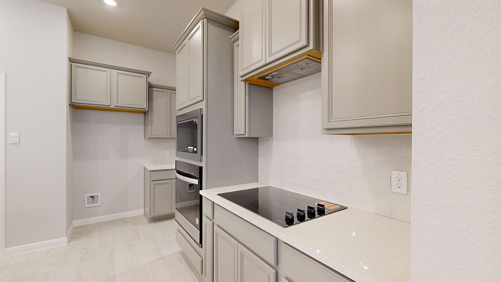 14537 Egon Road Salado, TX 76571 - Photo 4 of 27 Kitchen featuring gray cabinets, stainless steel appliances, decorative backsplash, light wood-type flooring, and light stone countertops