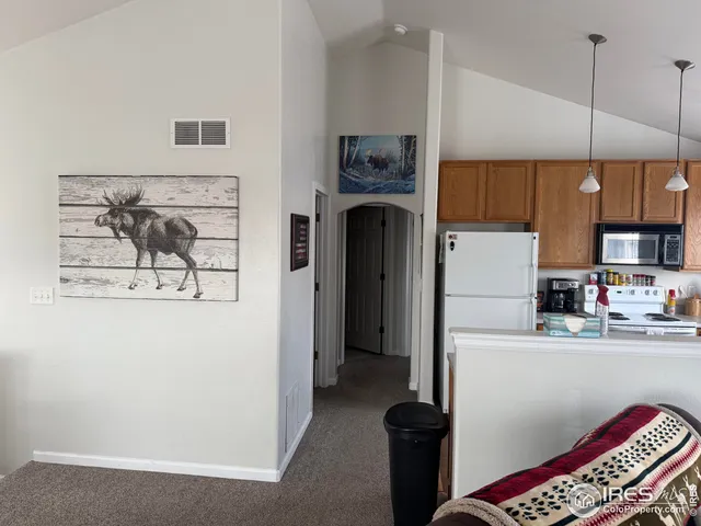 a kitchen with stainless steel appliances granite countertop a refrigerator a stove and a sink with wooden floor