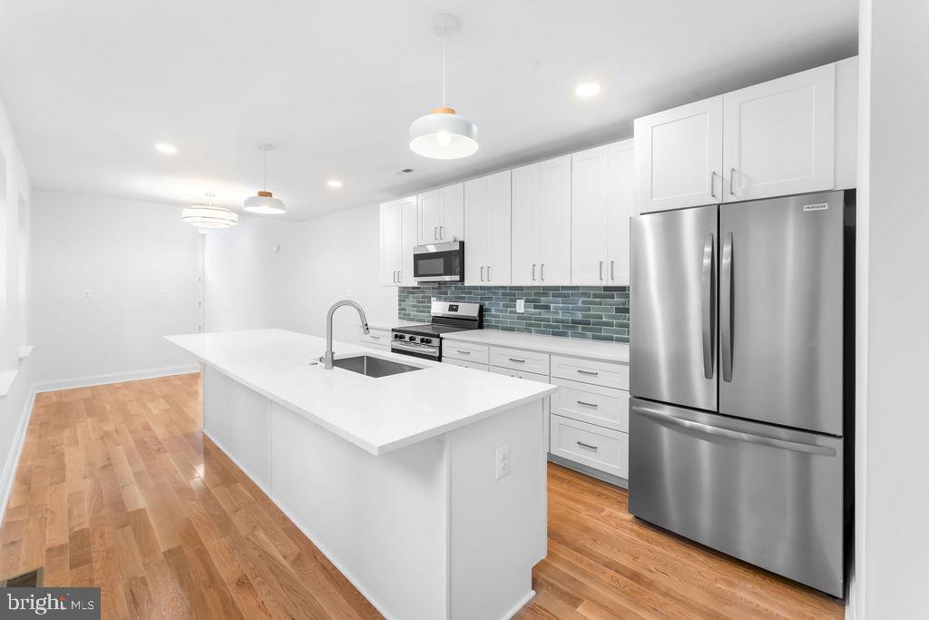 40 South Fulton Avenue Baltimore, MD 21223 - Photo 11 of 42 a kitchen with a refrigerator a sink and cabinets